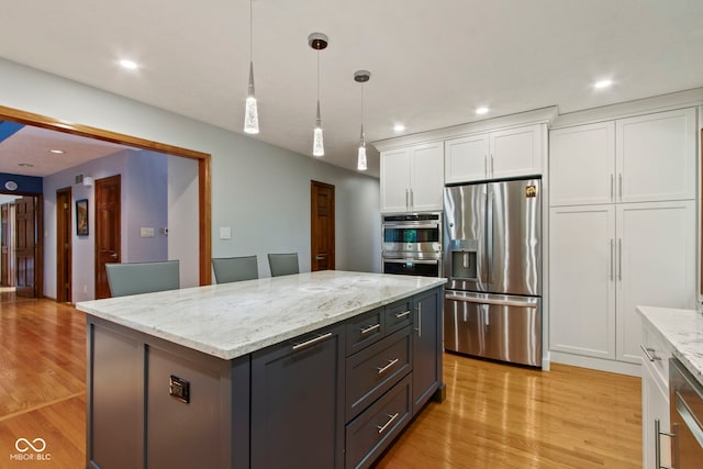 7426 Shadow Wood Dr, Indianapolis, IN 46254 - kitchen with appliances with stainless steel finishes, white cabinetry, light wood-type flooring, pendant lighting, and recessed lighting