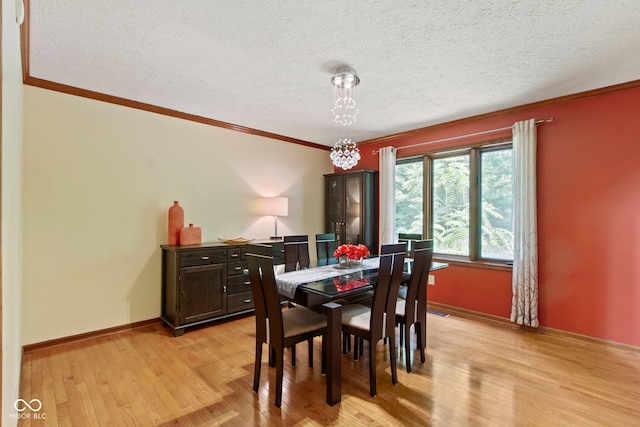 7426 Shadow Wood Dr, Indianapolis, IN 46254 - dining room featuring light wood-type flooring, crown molding, a textured ceiling, baseboards, and a chandelier