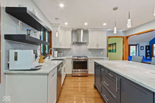 7426 Shadow Wood Dr, Indianapolis, IN 46254 - kitchen with wall chimney exhaust hood, stainless steel appliances, white cabinetry, light stone counters, and hanging light fixtures