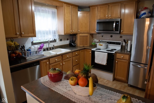7402 Broadview Dr, Indianapolis, IN 46227 - kitchen featuring appliances with stainless steel finishes, a sink, backsplash, dark countertops, and brown cabinets