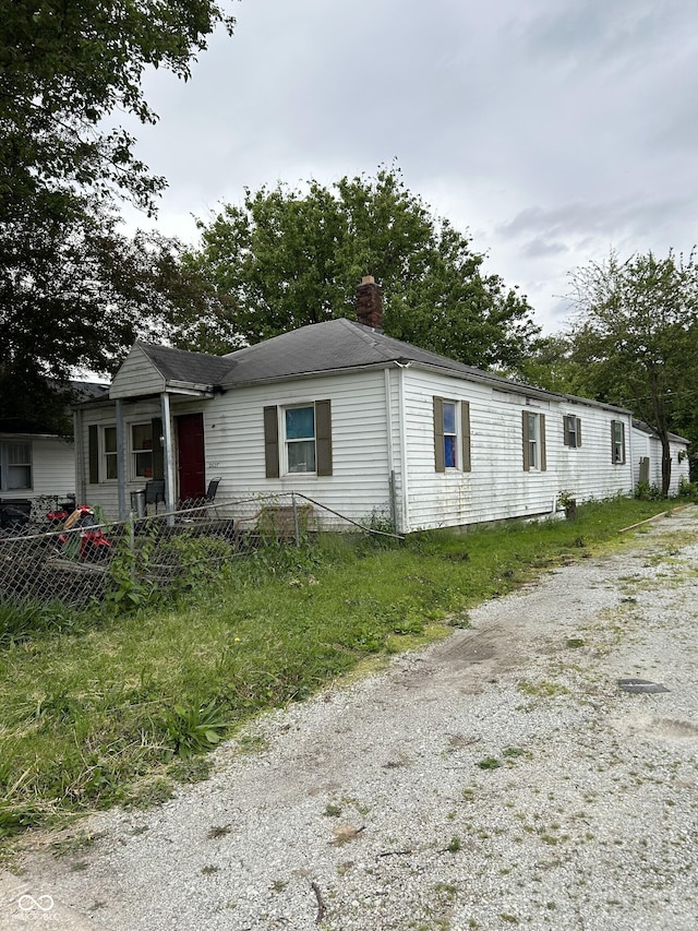 2627 Lincoln St, Anderson, IN 46016 - view of front facade with a chimney and gravel driveway