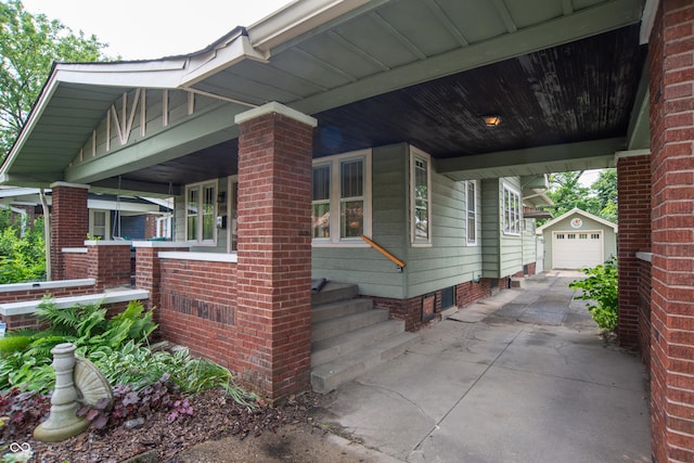 5133 E Michigan St, Indianapolis, IN 46219 - view of home's exterior featuring an outbuilding, concrete driveway, and covered porch