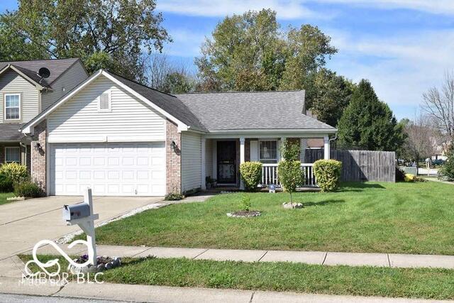 5216 Lakeside Manor Blvd, Indianapolis, IN 46254 - view of front of home featuring a garage, driveway, a porch, and brick siding