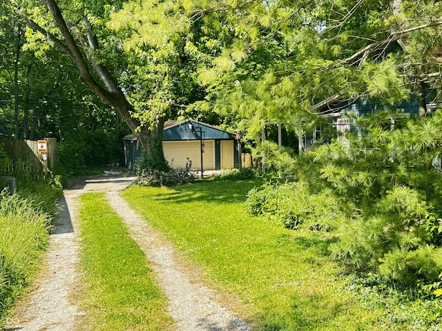 1206 Mcdougal St, Indianapolis, IN 46203 - view of grassy yard with driveway, an outbuilding, and a garage