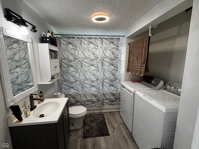 1206 Mcdougal St, Indianapolis, IN 46203 - bathroom with washer and clothes dryer, a textured ceiling, toilet, vanity, and wood finished floors