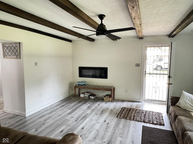 1206 Mcdougal St, Indianapolis, IN 46203 - unfurnished living room with ceiling fan, wood finished floors, beam ceiling, baseboards, and a textured ceiling