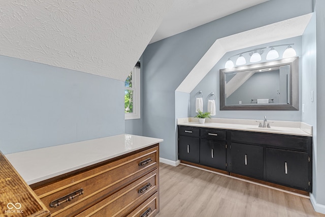 7630 Blain Way, Indianapolis, IN 46254 - bathroom with vanity, wood finished floors, a textured ceiling, lofted ceiling, and baseboards