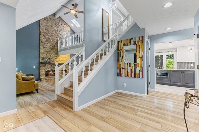 7630 Blain Way, Indianapolis, IN 46254 - stairs featuring a ceiling fan, a fireplace, wood finished floors, baseboards, and recessed lighting
