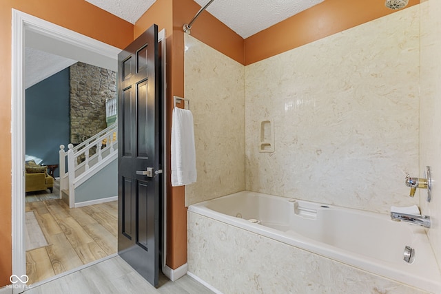 7630 Blain Way, Indianapolis, IN 46254 - bathroom with wood finished floors, a textured ceiling, and a combined bath / shower with marble appearance