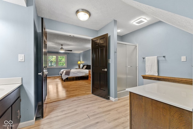 7630 Blain Way, Indianapolis, IN 46254 - ensuite bathroom featuring a shower stall, wood finished floors, a textured ceiling, and baseboards