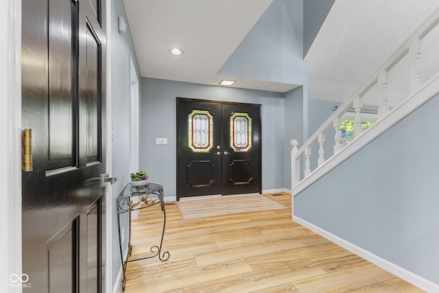 7630 Blain Way, Indianapolis, IN 46254 - entrance foyer with french doors, wood finished floors, stairs, baseboards, and recessed lighting