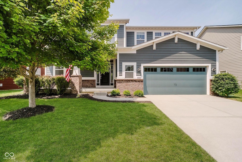 10962 Stoneleigh Dr, Noblesville, IN 46060 - view of front of house with brick siding, driveway, a front yard, and a garage