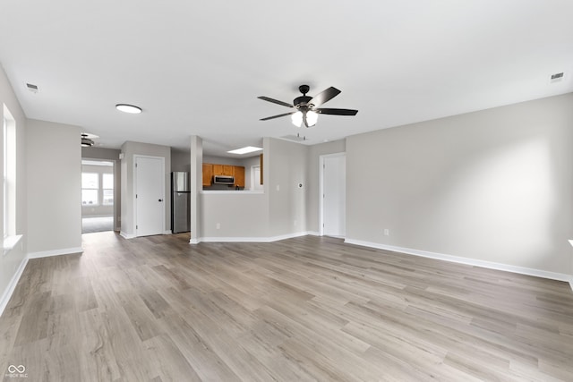 1313 Kenwood Dr, Greenwood, IN 46143 - unfurnished living room featuring a ceiling fan, light wood finished floors, and baseboards