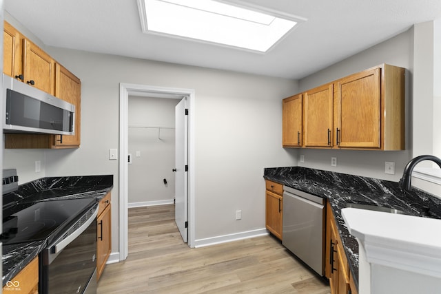 1313 Kenwood Dr, Greenwood, IN 46143 - kitchen with stainless steel appliances, light wood-style floors, a sink, baseboards, and dark stone counters