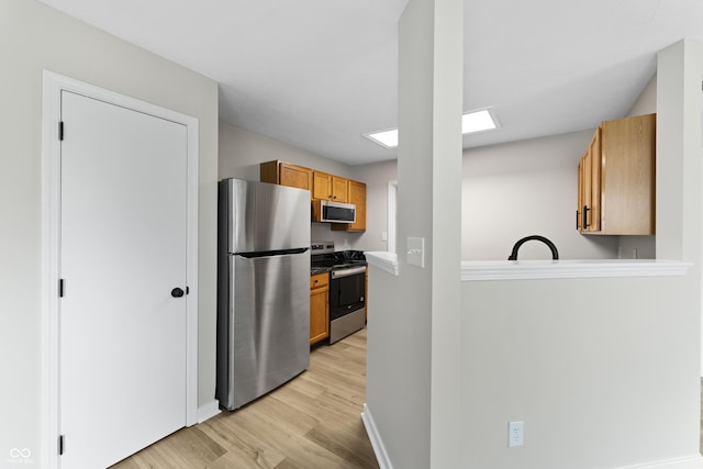 1313 Kenwood Dr, Greenwood, IN 46143 - kitchen with appliances with stainless steel finishes, light wood-type flooring, brown cabinetry, and baseboards