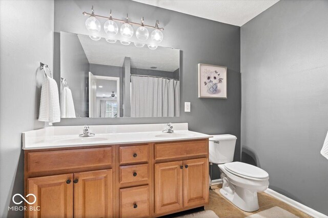 1905 Persimmon Grove Dr, Indianapolis, IN 46234 - bathroom with double vanity, toilet, tile patterned flooring, baseboards, and curtained shower
