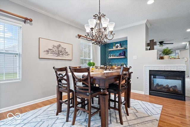 1905 Persimmon Grove Dr, Indianapolis, IN 46234 - dining room with ornamental molding, light wood-type flooring, a chandelier, a multi sided fireplace, and baseboards