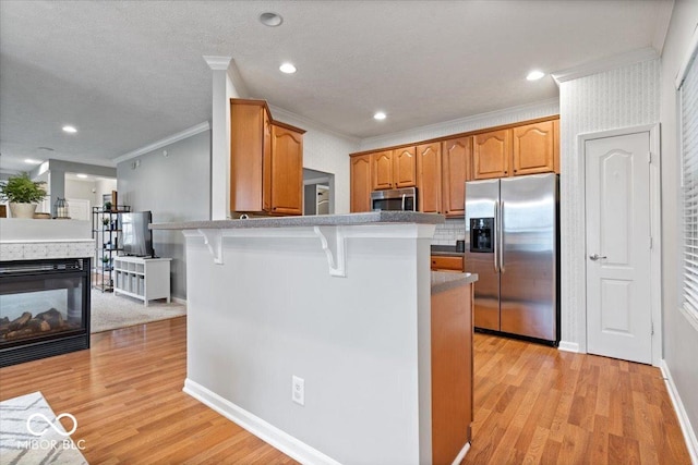 1905 Persimmon Grove Dr, Indianapolis, IN 46234 - kitchen with appliances with stainless steel finishes, crown molding, a kitchen breakfast bar, light wood-style flooring, and a peninsula