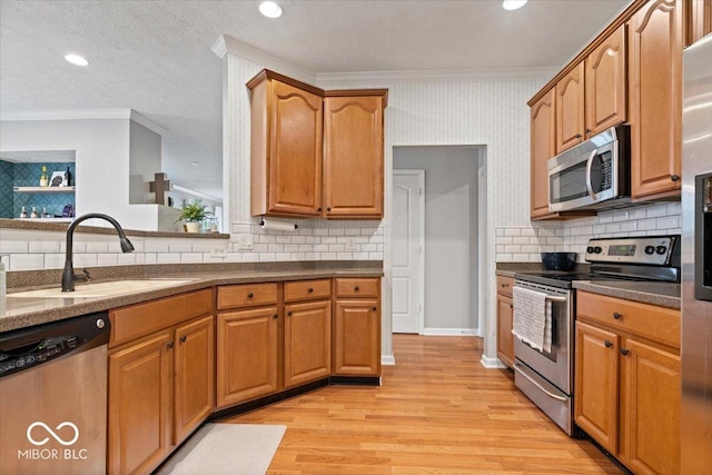 1905 Persimmon Grove Dr, Indianapolis, IN 46234 - kitchen featuring appliances with stainless steel finishes, crown molding, a sink, light wood-type flooring, and tasteful backsplash