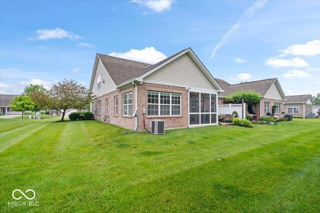 1905 Persimmon Grove Dr, Indianapolis, IN 46234 - rear view of property featuring central AC, brick siding, a sunroom, and a lawn