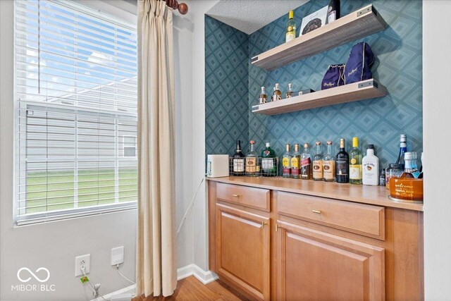 1905 Persimmon Grove Dr, Indianapolis, IN 46234 - indoor dry bar featuring wallpapered walls, light wood-type flooring, and baseboards