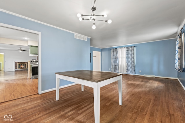 308 Hickory Hill Dr, Terre Haute, IN 47802 - unfurnished dining area featuring a chandelier, wood finished floors, baseboards, a glass covered fireplace, and a ceiling fan