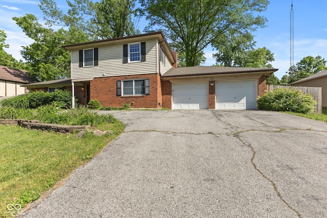 308 Hickory Hill Dr, Terre Haute, IN 47802 - traditional-style house featuring brick siding, an attached garage, and driveway