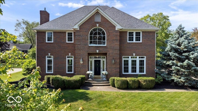 9973 Woods Edge Dr, Fishers, IN 46037 - view of front facade with a chimney, a front lawn, and brick siding