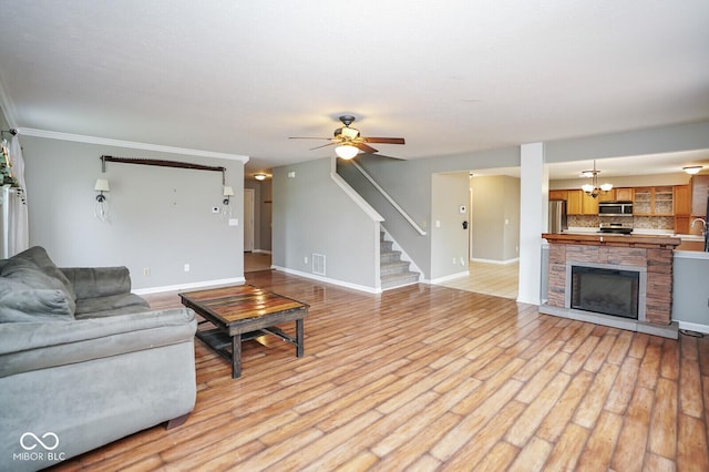 11198 N 650 W, Fountaintown, IN 46130 - living room with stairs, baseboards, ceiling fan, light wood-style floors, and crown molding