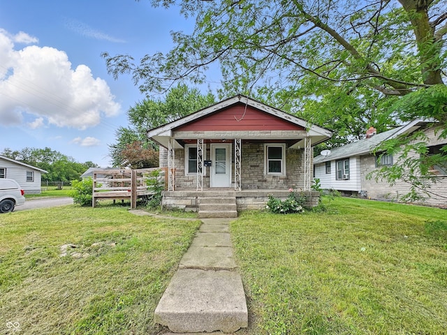 3526 E Vermont St, Indianapolis, IN 46201 - view of front facade featuring stone siding, a front yard, and a porch