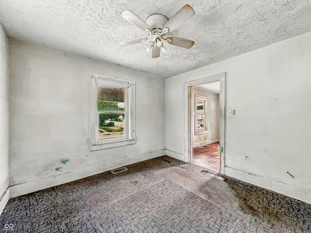 3526 E Vermont St, Indianapolis, IN 46201 - unfurnished room featuring healthy amount of natural light, a textured ceiling, a ceiling fan, and baseboards
