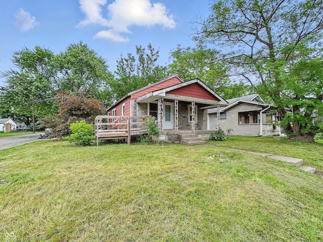 3526 E Vermont St, Indianapolis, IN 46201 - view of front of house with stone siding, a front lawn, and a porch