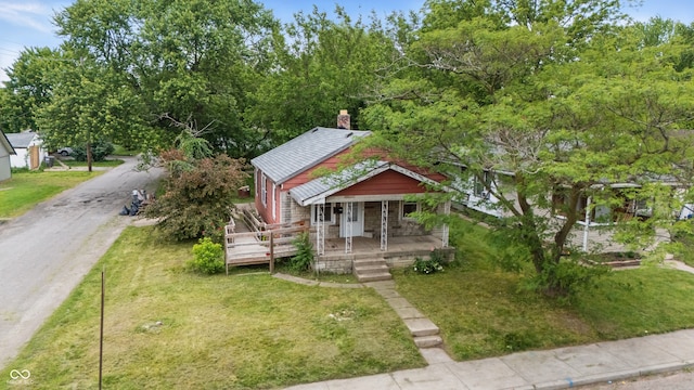 3526 E Vermont St, Indianapolis, IN 46201 - view of front of home featuring a porch, a chimney, and a front yard