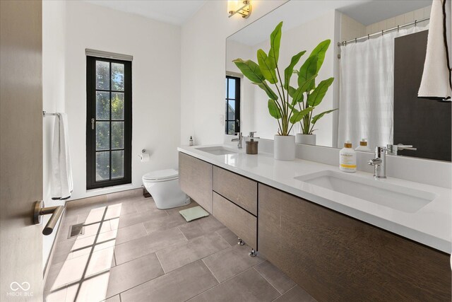 1818 N Pennsylvania St, Indianapolis, IN 46202 - full bathroom featuring toilet, double vanity, and tile patterned flooring