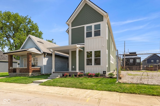 1405 Deloss St, Indianapolis, IN 46201 - view of front of property featuring a porch, board and batten siding, and a front lawn