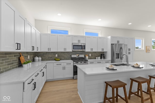 1405 Deloss St, Indianapolis, IN 46201 - kitchen featuring appliances with stainless steel finishes, a sink, a kitchen breakfast bar, backsplash, and recessed lighting
