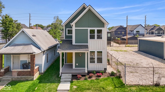 1405 Deloss St, Indianapolis, IN 46201 - view of front of house with board and batten siding, covered porch, a residential view, and a shingled roof