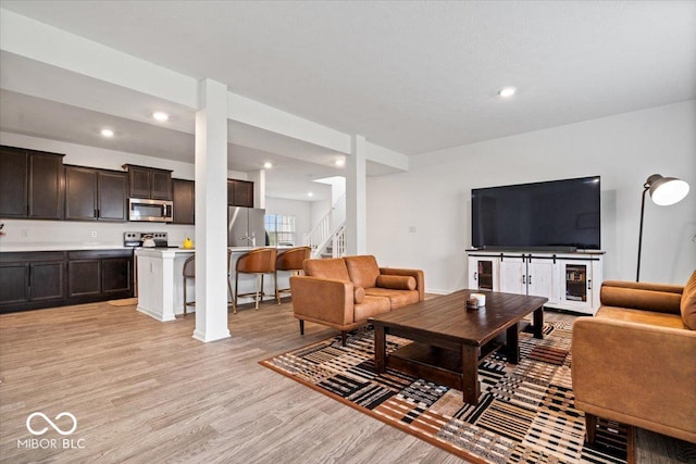 6507 W Whispering Way, Greenfield, IN 46140 - living area featuring light wood-type flooring, stairs, and recessed lighting