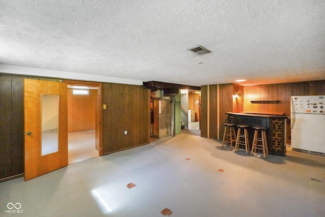 6133 Ashway Ct, Indianapolis, IN 46224 - unfurnished living room featuring a dry bar, a textured ceiling, wood walls, finished concrete flooring, and stairs