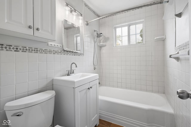 2164 E Raymond St, Indianapolis, IN 46203 - bathroom with toilet, vanity, washtub / shower combination, and tile walls