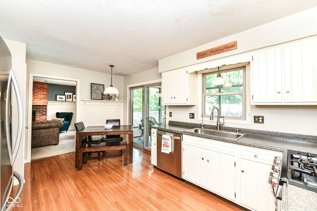6580 Kings Ct, Avon, IN 46123 - kitchen with stainless steel appliances, light wood-type flooring, dark countertops, white cabinets, and a textured ceiling