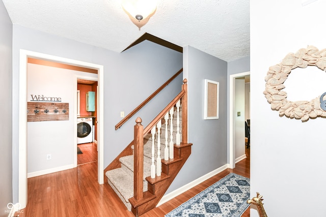 6580 Kings Ct, Avon, IN 46123 - stairway featuring washer / dryer, wood finished floors, and a textured ceiling