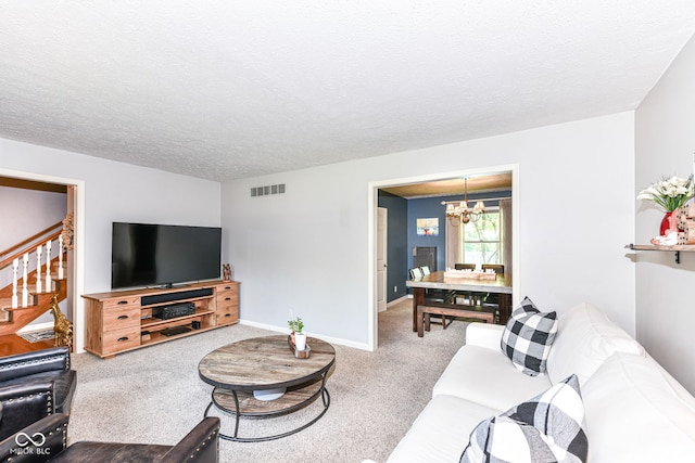 6580 Kings Ct, Avon, IN 46123 - carpeted living room featuring a chandelier, a textured ceiling, and stairs