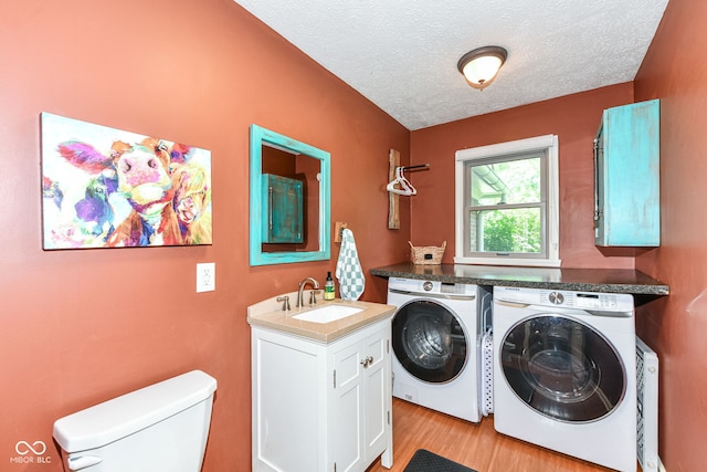 6580 Kings Ct, Avon, IN 46123 - washroom with washer and clothes dryer, a textured ceiling, and light wood-style flooring