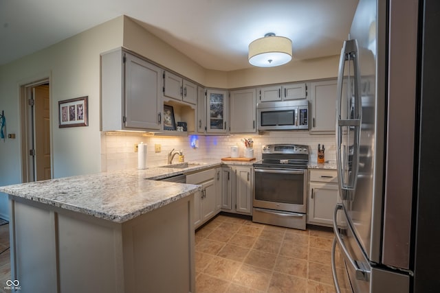131 Olde Mill Bay, Indianapolis, IN 46260 - kitchen featuring stainless steel appliances, a peninsula, a sink, tasteful backsplash, and light stone countertops