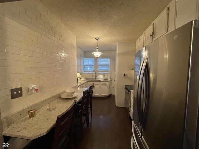 9467 N Michigan Rd, Fairland, IN 46126 - kitchen featuring appliances with stainless steel finishes, dark wood-style flooring, white cabinets, a sink, and light stone countertops