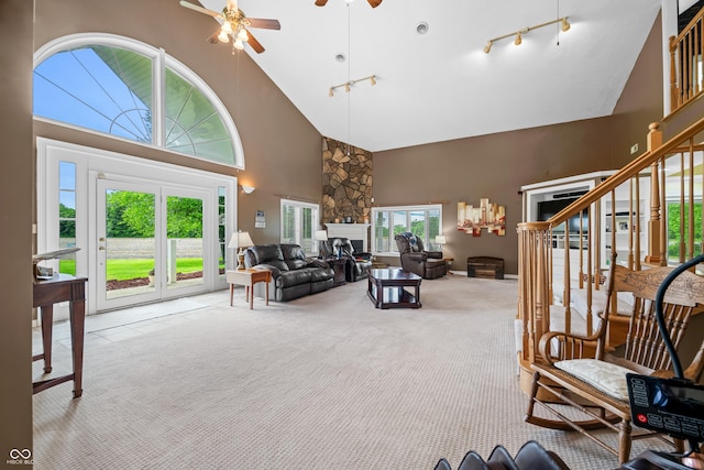5439 E Kinderhook Rd, Scottsburg, IN 47170 - living area with high vaulted ceiling, a stone fireplace, ceiling fan, carpet, and stairs