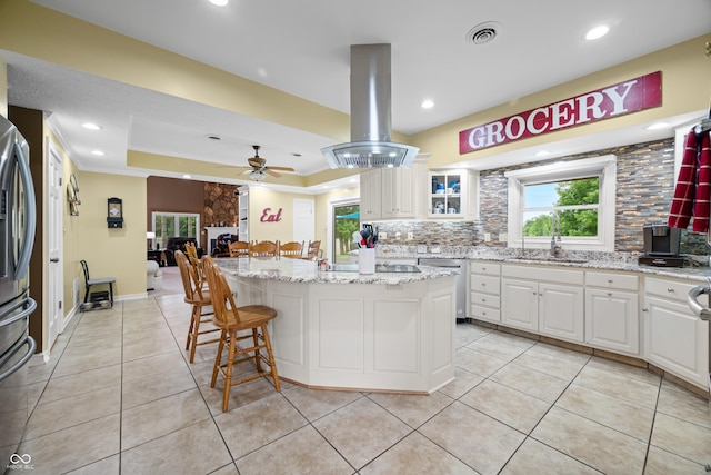 5439 E Kinderhook Rd, Scottsburg, IN 47170 - kitchen featuring a sink, island range hood, appliances with stainless steel finishes, tasteful backsplash, and a kitchen bar