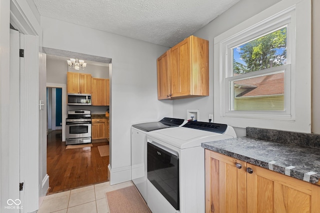 245 S Washington St, Danville, IN 46122 - laundry area with independent washer and dryer, a chandelier, light tile patterned flooring, and cabinet space