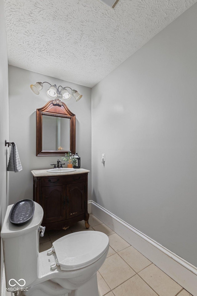 245 S Washington St, Danville, IN 46122 - bathroom with toilet, tile patterned floors, vanity, a textured ceiling, and baseboards